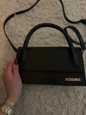 Svart väska  -  Svart väska, väskan har både handtag och en lång axelrem så du kan bära den flera sätt. Skick som ny! 