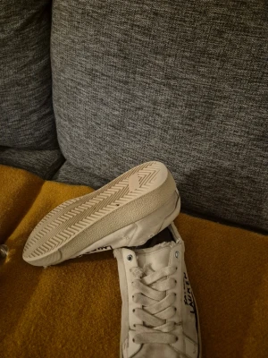 Vita sneakers i canvas med snörning - Klassiska vita sneakers i canvas med snörning och platt sula. Skorna har en enkel och stilren design med rund tå och gummisula. Perfekta för en avslappnad och trendig look. Även jävligt bra skick och billigt pris!