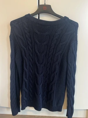 Mörkblå kabelstickad tröja S - Säljer en mörkblå kabelstickad tröja i storlek S. 