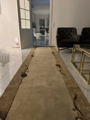 Beige långsmal matta med blommönster - Säljer en beige långsmal matta med bruna kanter och diskreta blommönster längs sidorna. Mattan har en mjuk yta och passar perfekt i en hall eller korridor. Färgerna är neutrala vilket gör den enkel att matcha med olika inredningsstilar.