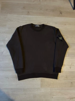 Brun Stone Island Crewneck Tröja - Fin stone island tröja i brun färg. Tröjan är i mycket bra skick och sparsamt använd. |  Äkta som allt annat jag säljer! ✅|  Storlek: XL | Skick: Mycket Bra Skick | Färg: Brun | Märke: Stone Island | Modell:  crewneck, tröja |  Mått: | Längd: 72 cm | Bröstvidd: 60 cm |  Hör gärna av dig vid frågor så svarar jag så fort jag kan! 🙂  