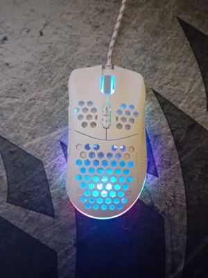 NOS M600 gamingmus med RGB-belysning - Säljer en vit NOS M600 gamingmus med RGB-belysning och honeycomb-design. Musen har sladd, DPI-knapp och genomskinliga hexagonmönster som släpper igenom ljuset. Perfekt för gaming och snygg setup.