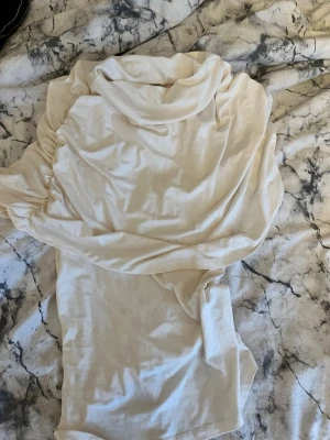 Vit ponchotopp  - En söt ”ponchotopp” från Gina tricot. Bara använd en gång och hittade ingen bild från hemsidan så andra bilden är samma tröja fast i röd istället för vit! I super fint skick!