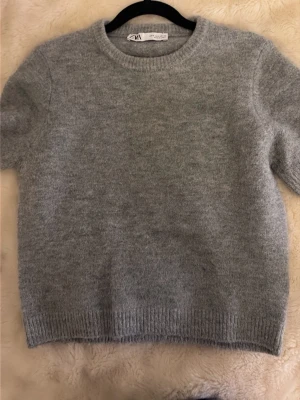 Grå stickad tröja från Zara - grå stickad tröja från Zara i storlek S. Tröjan har rund halsringning, ribbade muddar och är långärmad. 