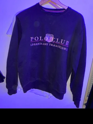 Mörkblå sweatshirt från Venson Polo Club - Mörkblå sweatshirt med rund hals från Venson Polo Club. Tryck på bröstet med texten 'Polo Club Legendary Traditions' och klubbmärke. Klassisk passform och ribbade muddar vid ärmslut och nederkant. Perfekt för en avslappnad och sportig stil.