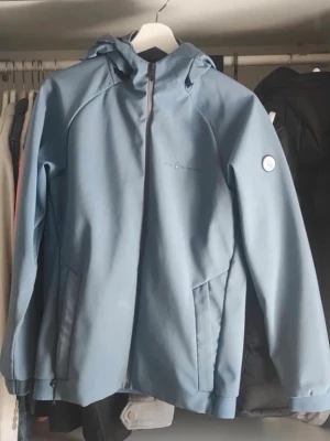 Sail racing jacka - Snygg blå vindjacka från sail racing med huva och dragkedja framtill. Jackan har två sidofickor med dragkedja och diskret logga på bröstet samt ärmen. Perfekt för blåsiga dagar och enkel att matcha till olika outfits.