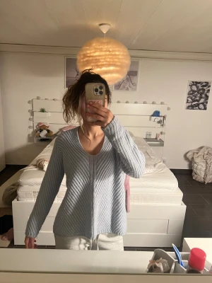 Ljusblå stickad kofta från Mango - Supermysig ljusblå stickad kofta från Mango i ullblandning. Den har ett ribbat, snedrandigt mönster och v-ringad hals. 