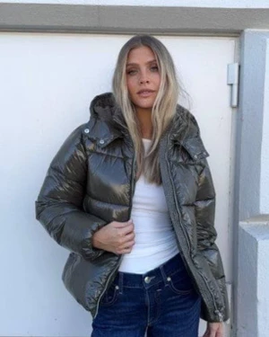 Grön glansig pufferjacka från Nelly - Super fin helt ny grön glansig jacka från Nelly i storlek m! Bra nu till vintern när det blir kallt. Den är lite mer grön än va det ser ut som på bilderna jag tagit själv (där ser den nästan brun ut) 