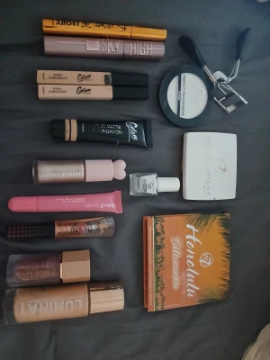 Sminkpaket  - Vissa saker är använda och vissa bara provade! 🤗 Säljer ett komplett sminkpaket med W7 Honolulu bronzerpalett i fyra matta nyanser, vit highlighter i kompakt förpackning, Maybelline Sky High mascara, Glam foundation och concealer, LUMINA foundation, ögonfransböjare, läppglans och blush. Perfekt för dig som vill testa olika looks!