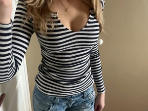 Randig ribbad långärmad topp - Säljer en snygg långärmad topp från Tara med marinblå och vita ränder. Toppen är ribbad, har v-ringad hals och sitter tight. Perfekt att styla med jeans eller kjol för en chill look. Materialet är mjuk bomull med lite stretch.