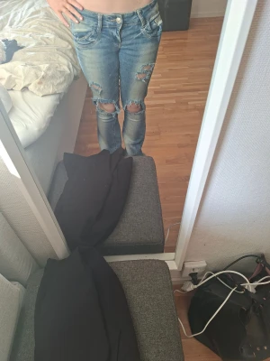 Blåa lågmidjade jeans med slitna detaljer - Säljer mina gina jeans för dem är för stora för mig, hålen har ja gjort själv dem är även lite slitna längst nere vid fötterna men de e inget man ser då tydligt💞💞