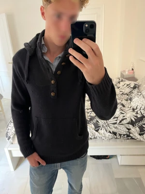 Svart stickad hoodie från French Connection - Svart stickad hoodie från French Connection med snygga knappar framtill och en soft look.       ————————————————————————                                                                   📐| Storlek: L                                                           👕| Märke: French Connection                             🔎 | Skick: Bra skick                                                ✍🏻 | Skriv om du har några frågor