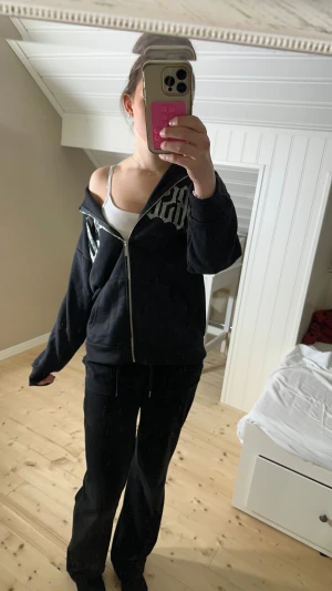 Svart hoodie med strass från New yorker - Svart hoodie med dragkedja från Faded. På bröstet står det 'OBSESSED' i stora bokstäver av strass. Tröjan har huva, fickor framtill och en oversized passform. Perfekt för dig som gillar streetstyle och statement-plagg. Använd fåtal gånger