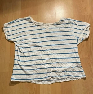 Vit t-shirt med blåa ränder - Vit t-shirt med blåa ränder.