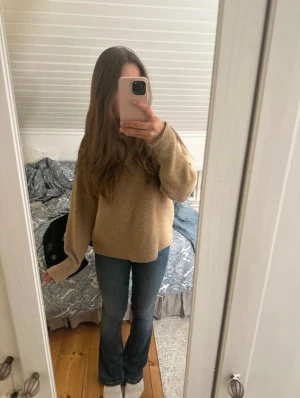 Blå bootcut jeans med låg midja - Snygga blå jeans med bootcut passform och låg midja. Jeansen har klassisk femficksdesign och är tillverkade i ett mjukt denimtyg som sitter bekvämt. Perfekt för dig som gillar en tidlös stil med lite extra vidd vid bensluten.