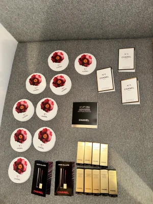Chanel parfym smink och mascara - Säljer flera Chanel sminkprover: N°1 de Chanel rouge i röd nyans, Noir Allure mascara i svart, samt Sublimage foundation i guldiga förpackningar. Allt är i miniformat, perfekt för att testa lyxiga produkter från Chanel.