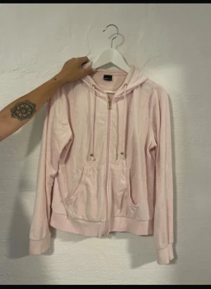 Ljusrosa hoodie med dragkedja - Mysig ljusrosa hoodie från Gina Tricot med huva och snörning. Tröjan har praktiska fickor framtill och en dragkedja i mitten. Tillverkad i mjuk bomullsmix som är skön mot huden. Perfekt för chill dagar och enkel att matcha med jeans eller leggings. Har nån småfläck men inte tvättat den så de kan gå bort. Står storlek L men passar M också🥰