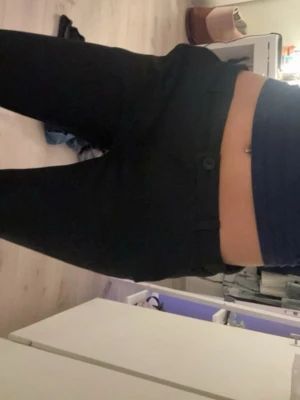 Svarta kostymbyxor med låg midja - Snygga svarta kostymbyxor med låg midja och raka ben. Klassisk design med knapp och dragkedja framtill. Perfekta för en stilren look och passar till många olika outfits.