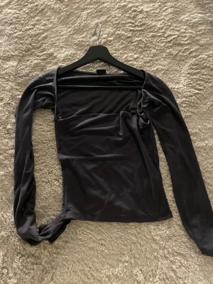 Gina tricot  långärmad topp  - Säljer en grå långärmad topp med trendig fyrkantig ringning. Toppen är i fint skick men jag torkade tröjan ute i solen och där av har den blivit solblekt, det är inget som syns i vanligt ljus men kan synas mot direkt ljus. Tröjan är ifrån soft touch kollektionen 