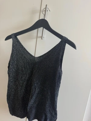 Glittrig topp - Glittrig topp som används några gånger. Köpt utomlands så vet ej vilket märke. Är som M i storlek skulle jag säga 
