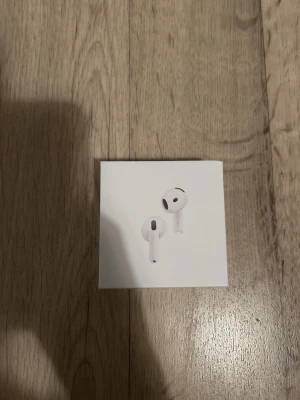 Apple AirPods 4 med ANC - Säljer ett par vita Apple AirPods 4 med ANC. Snygg och stilren design i plast med laddningsetui. Perfekta för musik, poddar och samtal. Levereras i originalförpackning.