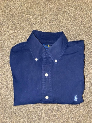 Mörkblå Ralph Lauren skjorta - Mörkblå Ralph Lauren skjorta. Storlek S, slim-fit, 100% cotton stretch. Använd ett fåtal gånger, 9/10 skick