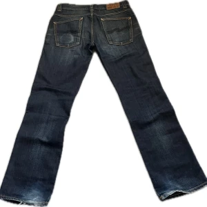 Nudie Jeans-SLIM JIM-32/32 Black Ink Vintage! - A pair of really great-looking Nudie Jeans Slim Jim. Size on tag is 32/32 (see exact measurements below). Fine condition, featuring some wear at the heels and signs of use such as a "snus fade" on the back pocket. Feel free to message me if you have any questions! • Waist: 42.5 cm • Thigh: 27 cm • Inseam: 79 cm • Total Length: 105 cm • Leg Opening: 21 cm 