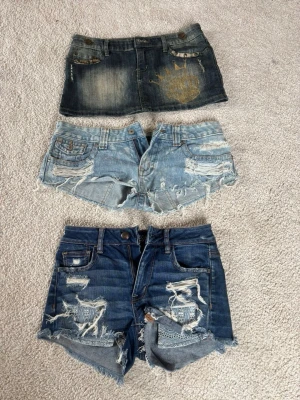 3 par jeansshorts i olika tvättar - Tre par jeansshorts i olika blå nyanser, alla med slitna detaljer och råa kanter. Ett par är mörkblå, ett par ljusblå och ett par mellanblå. Perfekta för en avslappnad stil och att matcha med t-shirt eller linne.