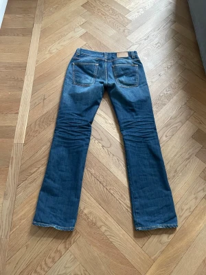 Nudie bootcut - Ett par nudie jeans med bootcut i modellen slim jim. Jeansen är i fint skick förutom en liten slitning på framfickan, som egentligen bara är snyggt! Midjan är 41 cm, längden är 107 cm. Skriv gärna vid funderingar!😊