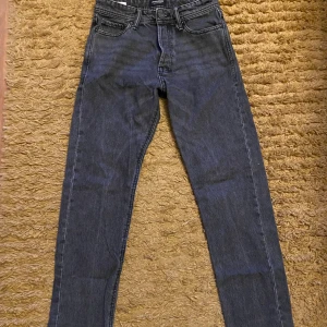 Svarta loose fit jeans Jack & Jones - Säljer ett par svarta loose fit jeans från Jack & Jones, modell Chris. Jeansen har klassisk femficksdesign, raka ben och normal midja. Perfekta för en avslappnad och trendig stil. Ena fickan syd men bara lite snyggare design🤩