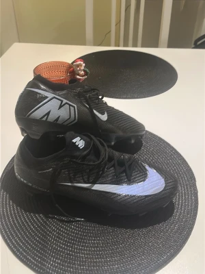 NIKE AIR ZOOM MERCURIAL VAPOR 16 ELITE FG SHADOW - SVART/BLÅ - Säljer ett par svarta Nike fotbollsskor inte använda så mycket säljer dom för ska gå över till adidas! Pris kan diskuteras