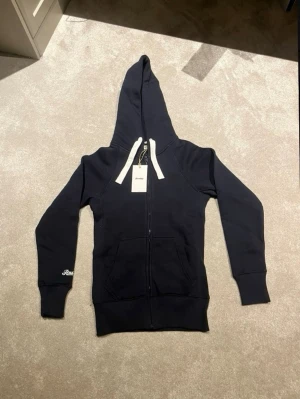 Russemerch-set XS! - Mörkblått mjukisset från Russemerch med matchande hoodie och byxor. Båda kommer i orginalförpackning och är oanvända + har prislapp kvar på. Säljs pga för liten storlek och kan ej lämnas tillbaka. Passar ca 160-170 cm, hör av er om minsta fundering💫