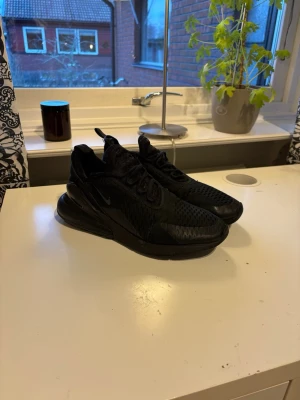 Svarta Nike 270 - Ett par riktigt feta Nike 270 som är helsvarta, bra skick och ingen bubbla är sprucken på sulorna, enda är små revor på sidan av vristen, men funkar absolut jöttebra