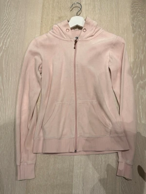 Kofta från Cubus - Snygg ljusrosa hoodie med dragkedja framtill och två fickor. Hoodien har ribbade muddar vid ärmslut och nederkant samt en klassisk huva med dragsko. Perfekt för en avslappnad och trendig look.