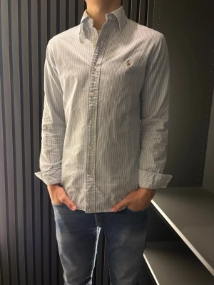 Ralph Lauren skjorta - Klassisk vit skjorta med blå ränder från Ralph Lauren. Skjortan är i helt nytt skick och har endast används ett fåtal gånger✅perfekt inför våren och sommaren☀️nypriss:1200kr mitt pris 449kr🤩 priset är inte hugget i sten🪨 och det är bara att skriva om du har några funderingar🤗