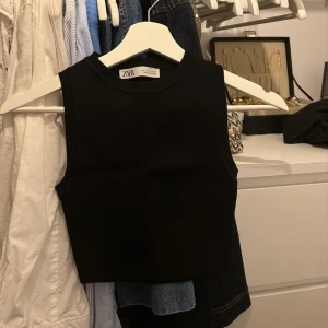 Svart croppad linnetopp - Svart croppad linnetopp utan ärmar från Zara, på bild två är de samma topp fast i vitt som jag också säljer