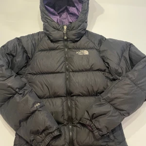 North face dunjacka XS dam - Super fin svartdunjacka från The North Face. Med liftkortsficka på vänsterarm. Inga repor eller förslitningar. 