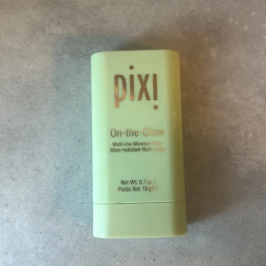 Pixi On-the-Glow stick - Pixi On-the-Glow är en multifunktionell fuktstick i ljusbeige nyans. Kommer i en mintgrön plastförpackning med guldtext. Perfekt att använda på både ansikte och kropp för extra glow och återfuktning. Enkel att ta med i väskan och applicera när som helst ENDAST testad på handen 