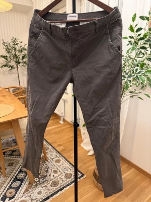 Olivgröna stretch chinos från Lindbergh - Snygga olivgröna chinos från Lindbergh White i stretchigt material för extra komfort. Klassisk rak passform med fickor fram och bak, bälteshällor och diskret knappstängning. Perfekta för en clean och stilren look.