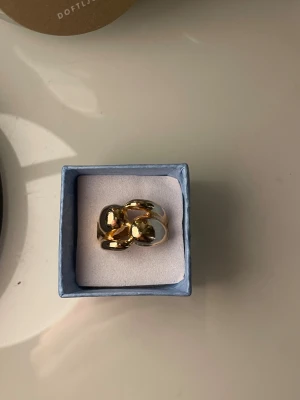 Chunky guldpläterad ring - Säljer en chunky ring i guldpläterad metall med en cool, organisk form. Ringen har en blank yta och känns riktigt statement. Perfekt för dig som gillar att sticka ut med accessoarerna.