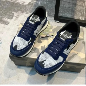 Valentino Garavani Rockrunner sneakers - Snygga Valentino Garavani Rockrunner sneakers i blått, vitt och svart med coolt camouflage-mönster. Skorna har snörning, rund tå och platt sula. Ovandelen är i stickad syntet och mocka, vilket ger en unik och modern vibe. Perfekta för dig som vill sticka ut med stil.