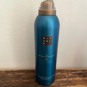 Rituals The Ritual of Hammam duschmousse - Rituals The Ritual of Hammam duschmousse i en snygg metallicblå flaska med bronsfärgat lock. Innehåller eukalyptus och arganolja för en fräsch och lyxig känsla. Perfekt för dig som gillar spa-vibes och vill ha en mjuk, väldoftande duschupplevelse.