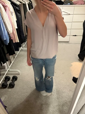 Ljuslila omlottblus från Åhléns - Säljer en ljuslila blus från Åhléns i storlek 38. Den är köpt second hand men använd bara några få ggr av mig. Blusen har några synliga stygn för att omlotten ska sitta ihop lite mer men inget man egentligen tänker på, finns bild på det på sista sidan. 