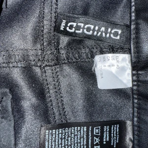 Svarta skinnbyxor från H&M Divided - Snygga svarta byxor i skinnimitation från H&M Divided. 