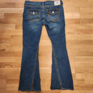 True Religion Joey Low Rise Flare Jeans - Säljer ett par blå True Religion jeans, dem har knappt använts så dem är i nyskick typ, Jeansen är hos min morsa jag inte bor hos så kommer inte orka åka dit och ta bild hur de sitter på om nån vill ha bild med dem på🥀🥀 pris kan diskuteras  