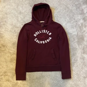 Hollister Hoodie vinröd - Hej! Säljer denna riktigt feta och otroligt trendiga vintage Hollister hoodien i vinröd färg! Storleken är Medium och sitter perfekt på mig som är 181cm och väger 68kg! Sitter riktigt bekvämt och är precis som en hoodie ska vara! Inga defekter förekommer 😁varmt välkommen att fråga frågor eller be om mått/bilder vid intresse av köp! Mvh DC 🔹