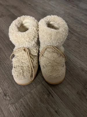 Beige fluffiga moon boots - Säljer ett par fluffiga uggs liknande skor! Nästan helt oanvända i storlek 41 men sitter som ett par 40. Säljer då dem är för stora och inte kom till användning ❤️Skriv vid intresse 