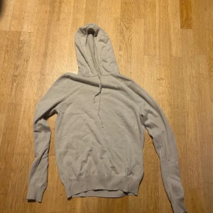 Beige hoodie i kashmir från Soft Goat - Mjuk och lyxig beige hoodie från Soft Goat i 100% kashmir. Har varit på fixning hos Soft goat själva och har fixat armbågarna. Skick 7/10 efter fixningen. Orginal pris är ~4000. 