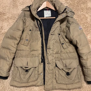 Moncler jacka  - Äldre modell men extremt sparsamt använd. Går att i maskin, seriestrippen tar dock skada som syns på en bild. Storleken är 1 alltså cirka S.  Verifiering finns från Vestiaire.