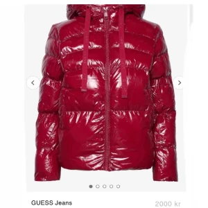 Röd pufferjacka från GUESS - Säljer en glansig röd pufferjacka från GUESS. Nypris 2000 mitt pris 1000. Som ny ända är att den man hänger upp jackan med gått av men man kan laga då jag gjort d förut. säljer för att jag har två! Skickar oftast inom en dag.❤️